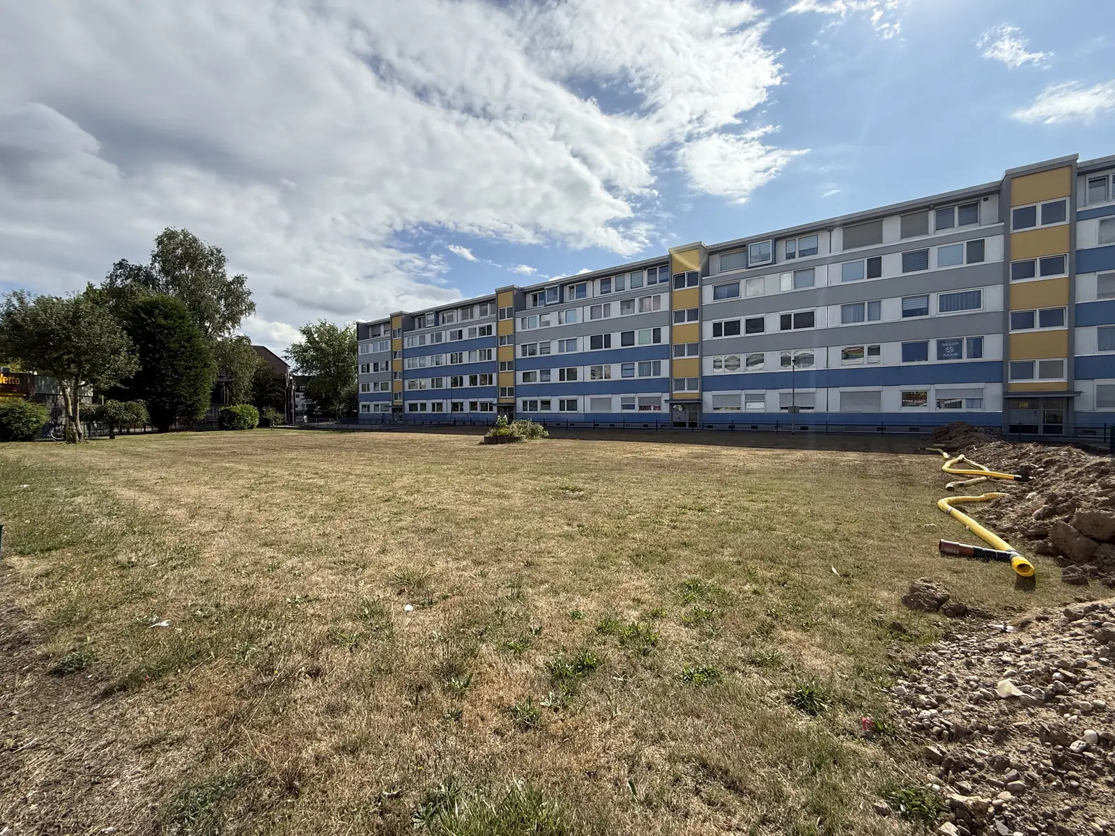 Außenansicht der Wohnanlage Holzweg 89 mit gepflegter Grünfläche im Sommer