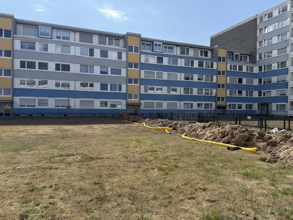 Blick auf die Hauszeile Holzweg 89 mit Eingängen und Grünfläche