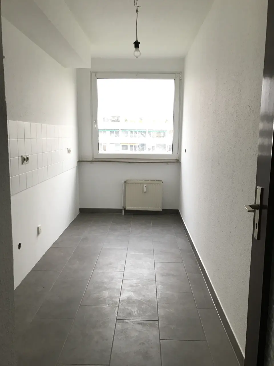 Separate Küche mit modernen grauen Bodenfliesen und Fenster