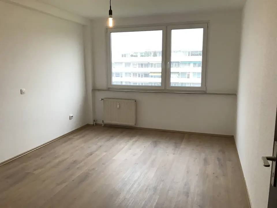 Schlafzimmer mit großem Fenster und hellem Boden